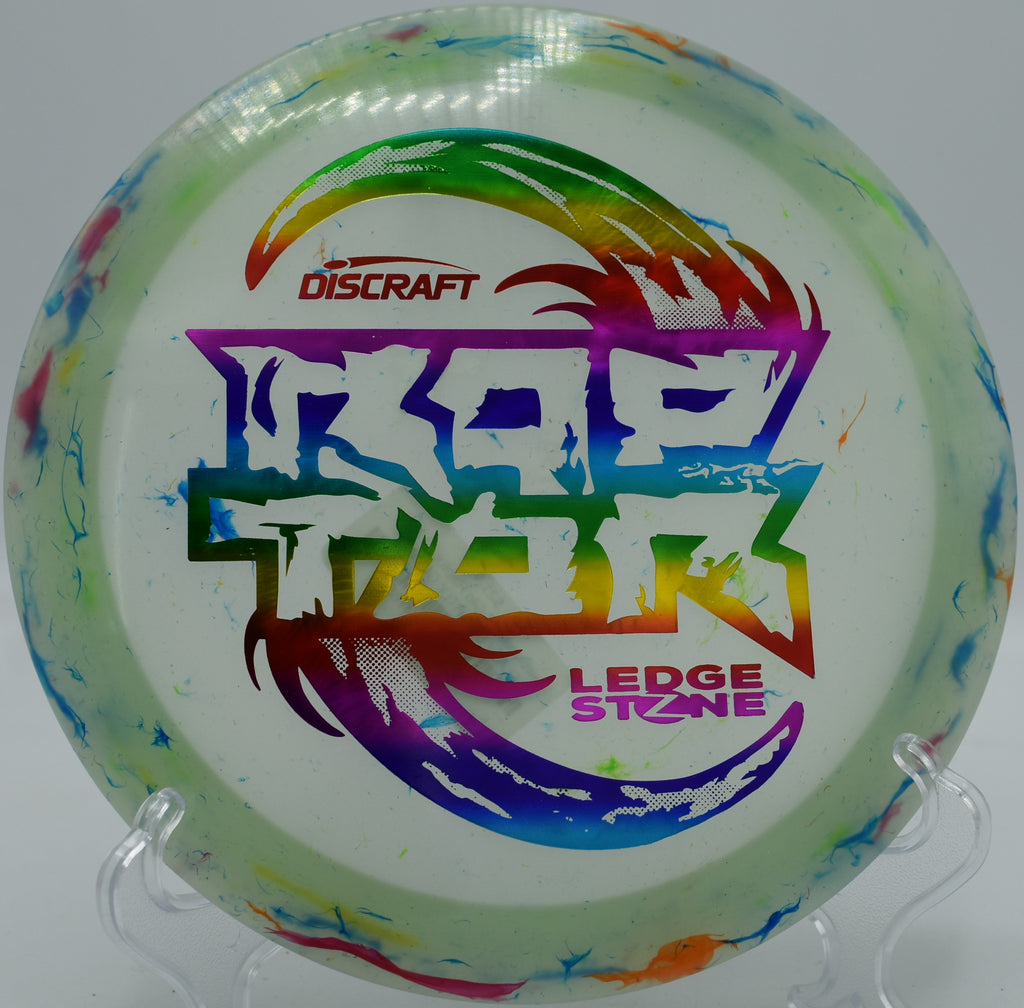 Jawbreaker Z Glo Raptor flashing its pastel glow blend mid-flight at Blue Ribbon Pines in East Bethel, Minnesota