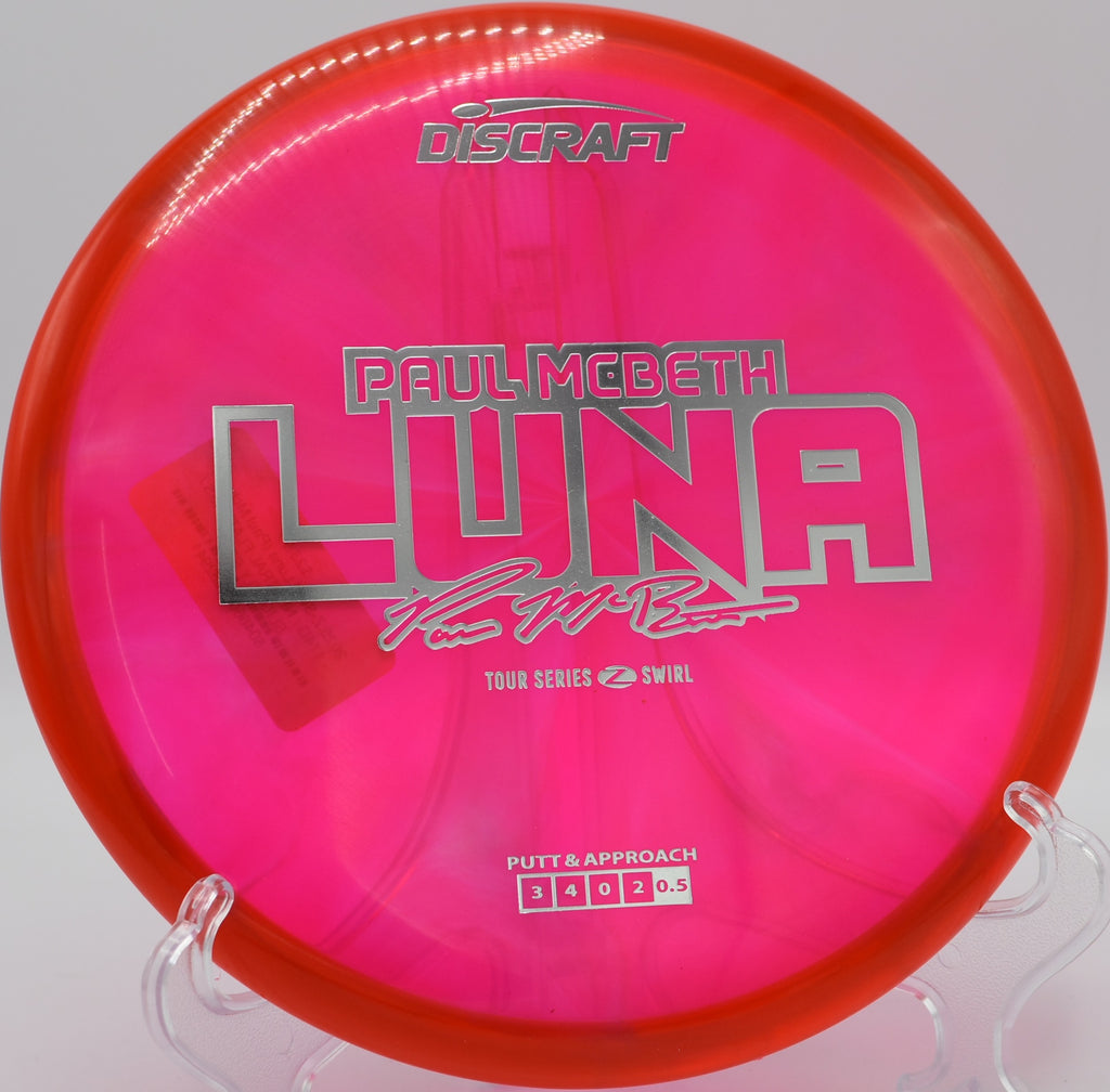 Paul McBeth Z Swirl Luna resting on the green at Idlewild Disc Golf Course in Burlington, Kentucky, featuring beautiful swirl patterns and consistent putting performance.


