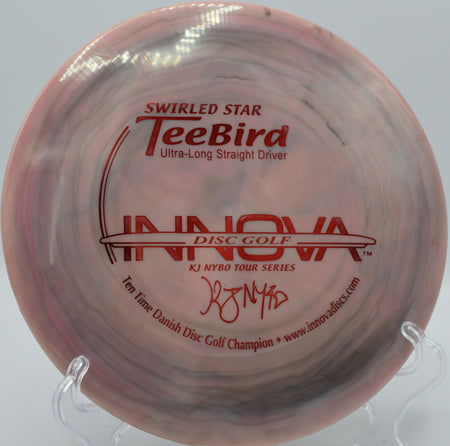 10X KJ Nybo Swirled Star TeeBird driver flying down a wooded fairway at Hornets Nest Disc Golf Course in Charlotte, North Carolina, known for its stable flight and tight-line accuracy.


