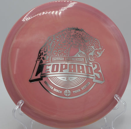 Swirly Star Leopard3 (2018 Hannah Leatherman) fairway driver carving a long, touchy turnover at Selkirk Shores Disc Golf Course in Pulaski, New York, maintaining finesse-driven glide, workable stability, and accurate line control for technical disc golf shots