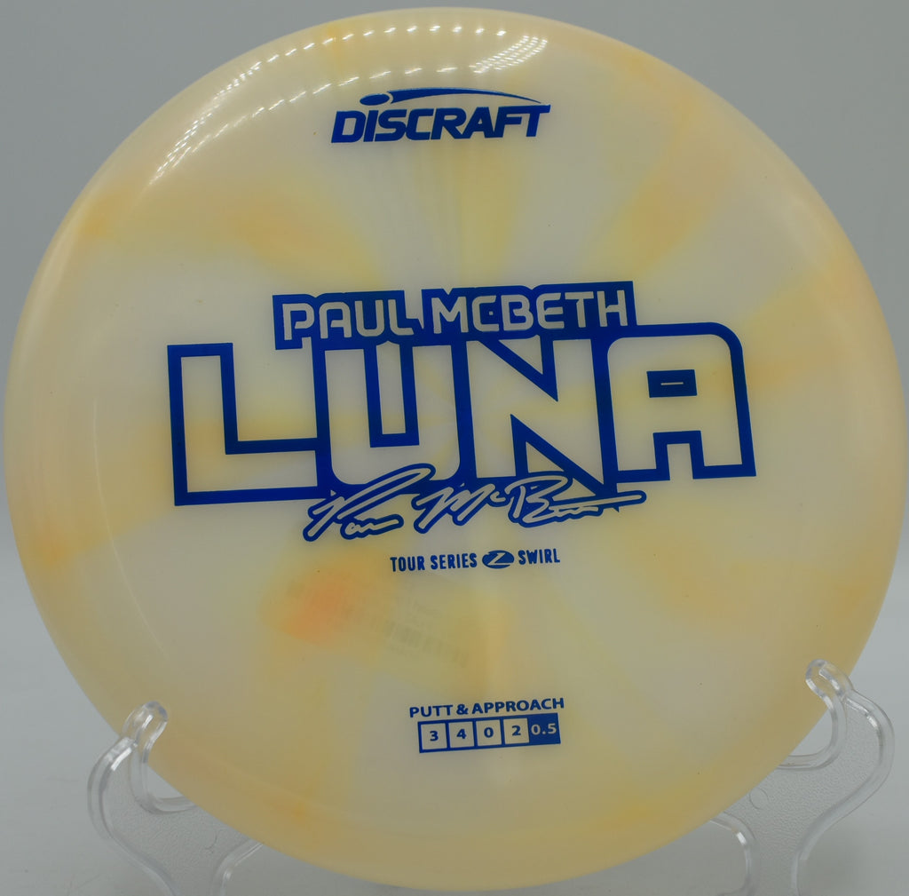 Paul McBeth Luna in Z Swirl plastic sitting on pine needles at Flip City DGC in Shelby, Michigan, great for touch forehands and windy putts.

