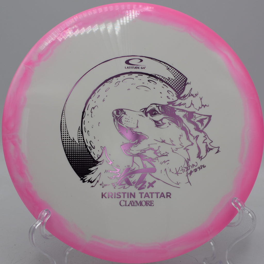 Latitude 64° 2024 Kristin Tattar Gold Orbit Claymore tour series midrange parked at Heritage Park Disc Golf Course in Frankfort, Kentucky.