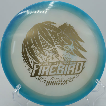 Disc golfer attacking a windy headwind hole with a 2024 Sexton Firebird, holding a sharp hyzer line at Maple Hill Gold in Leicester, MA.

