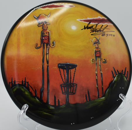Stokely Universe ESP Buzzz signed by Scott Stokely displayed on the fairway at Lake Marshall Disc Golf Course in Montross, Virginia, featuring vibrant ESP plastic and trusted Buzzz stability for precision midrange control.








