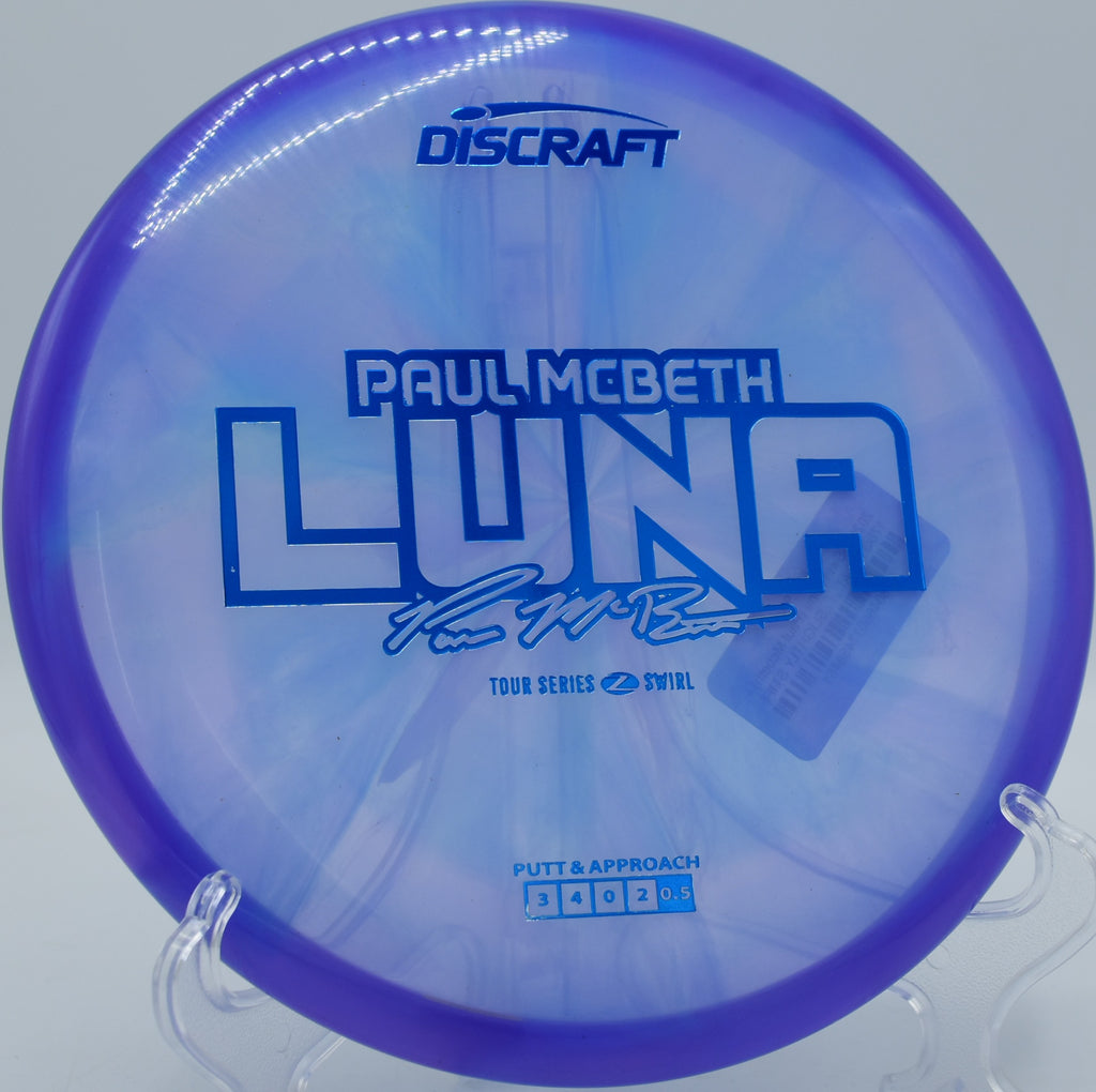 Paul McBeth Z Swirl Luna resting on lush fairway grass at Bryant Lake Park in Eden Prairie, Minnesota, favored for approach precision.

