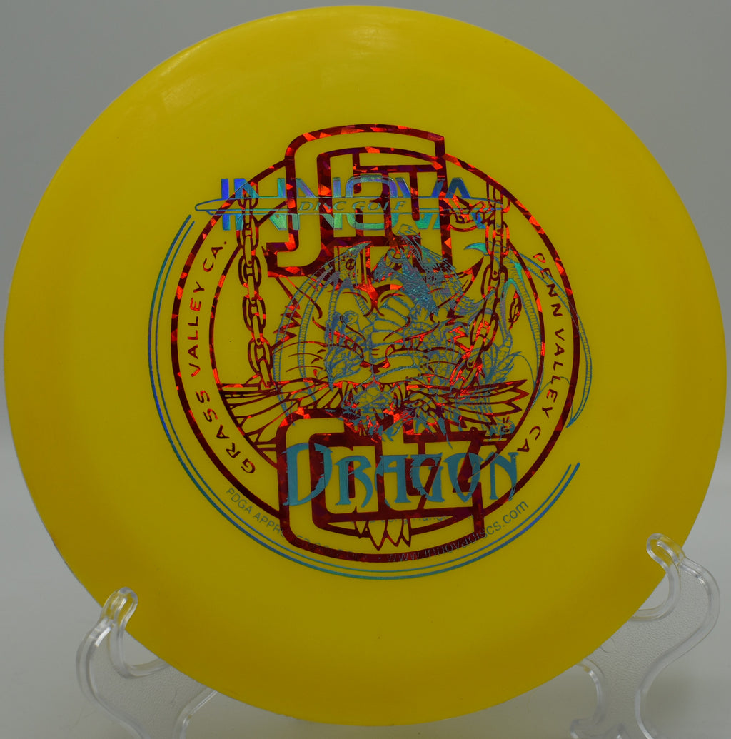 DX Dragon floating near the edge of a water hazard at Lakewood King County Disc Golf Course in Washington, highlighting its lightweight build, high glide, and water-floating plastic ideal for newer players.