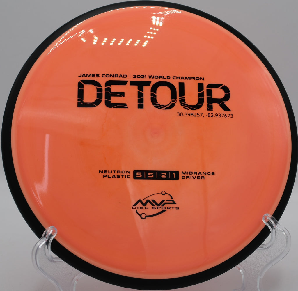 MVP Detour in premium Neutron plastic resting under the basket at Maple Hill Disc Golf Course in Leicester, Massachusetts, designed for precise placement and neutral flight.

