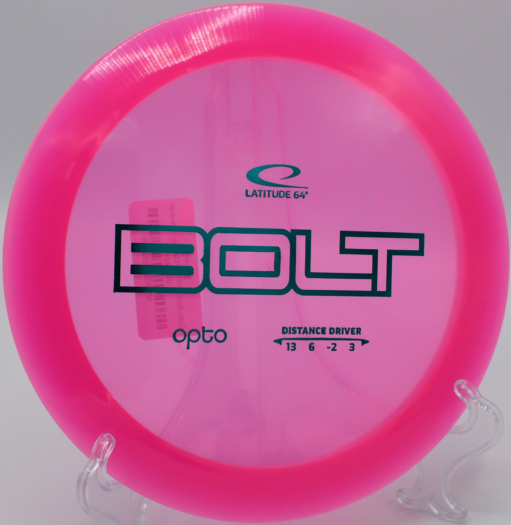 Bright Opto Bolt disc resting on a sandy bunker at Rattlesnake Ridge Disc Golf Course.

