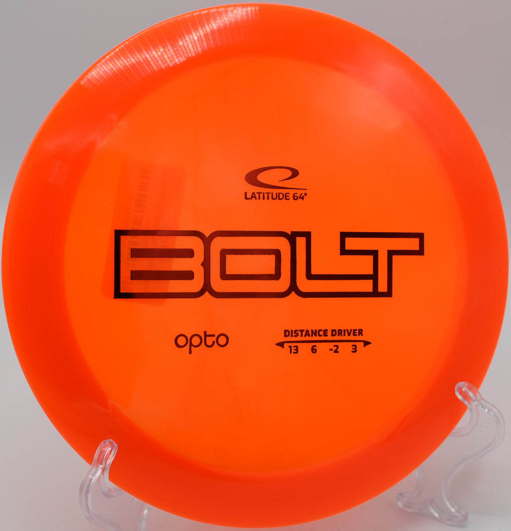 A red Opto Bolt golf disc perched atop a rock at Timberline Trails Disc Golf Course.