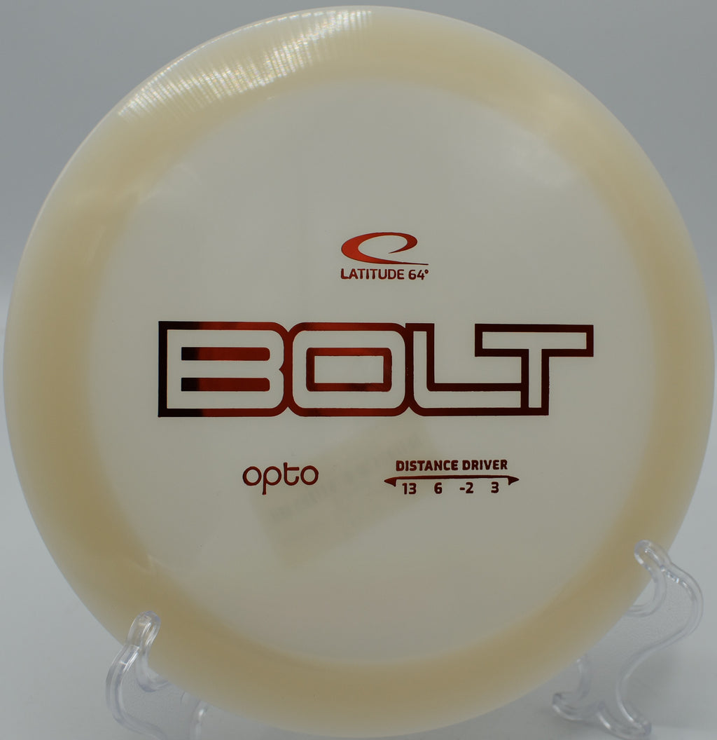 A close-up of an Opto Bolt disc against the backdrop of Cascade Peaks Disc Golf Course.