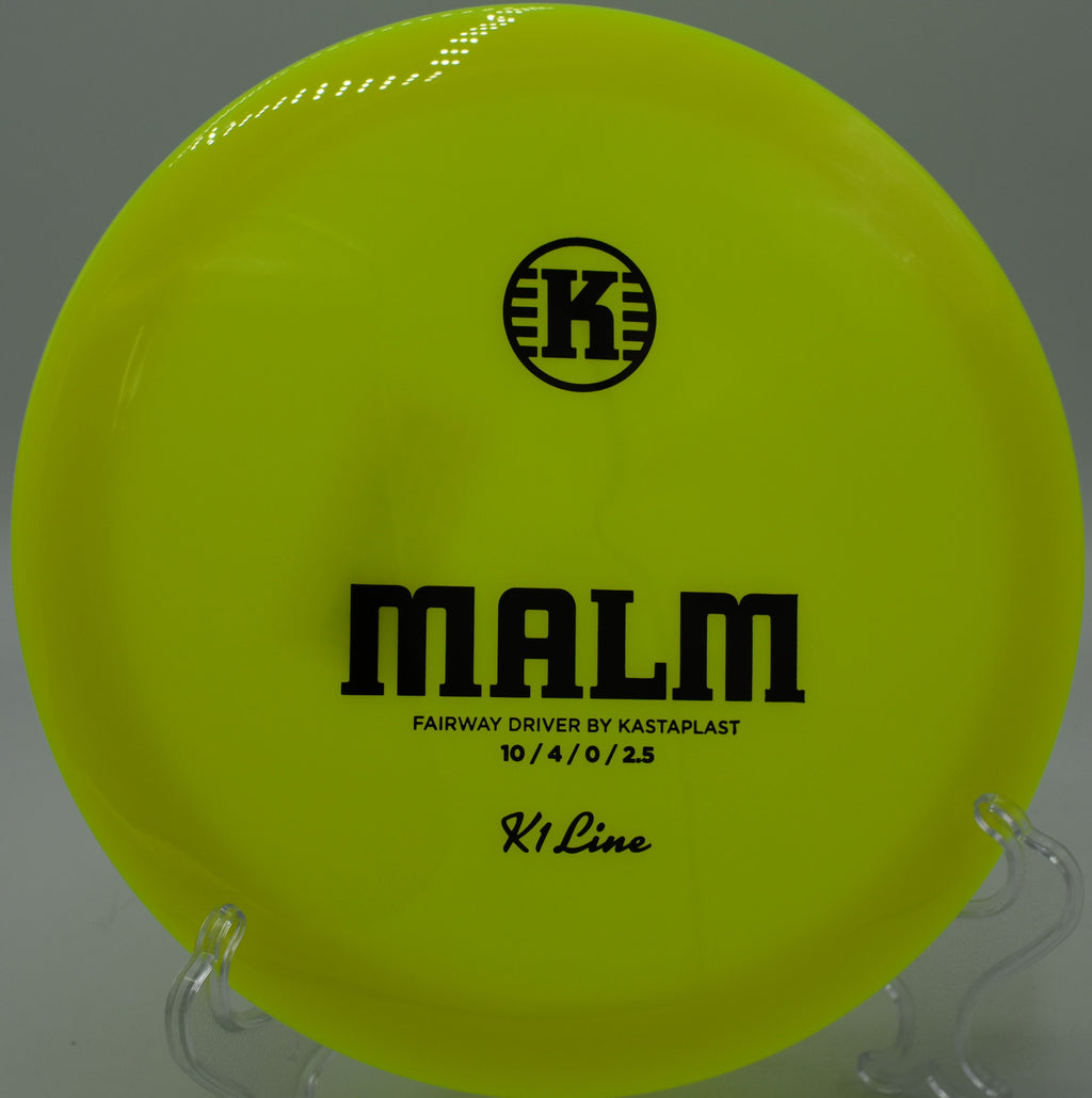 K1 Malm spinning straight through a tight wooded gap at Sabattus Disc Golf Course in Maine, heading dead-center.

