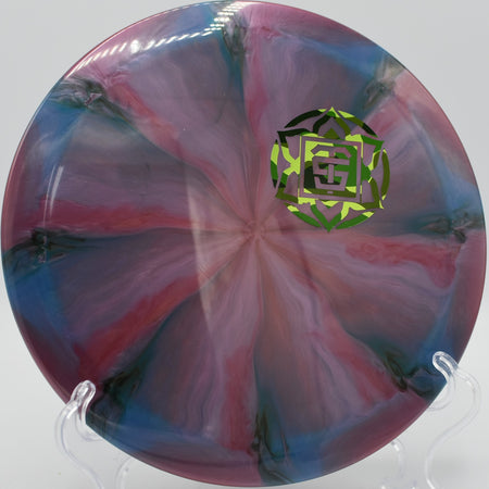 Close-up of TSA Nebula Ethereal Omen resting on the fairway at DeLaveaga Disc Golf Course in Santa Cruz, California, showcasing premium swirled plastic and reliable grip.

