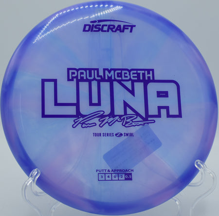 Discraft Luna in swirled plastic carving a tight anhyzer line on a wooded tunnel putt at Nevin Park in Charlotte, NC.

