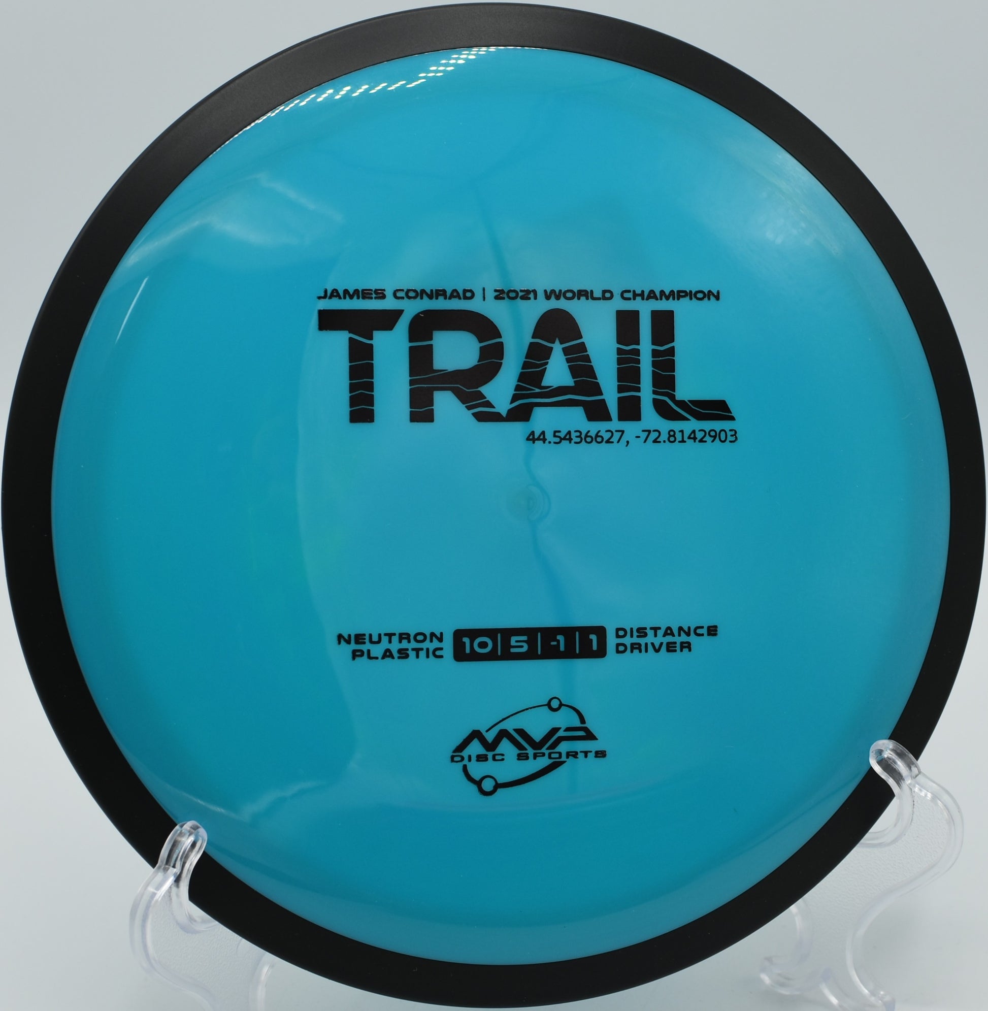 MVP Neutron Trail spinning over scenic fairways at Black Falcon Disc Golf Course, Montague, Michigan.