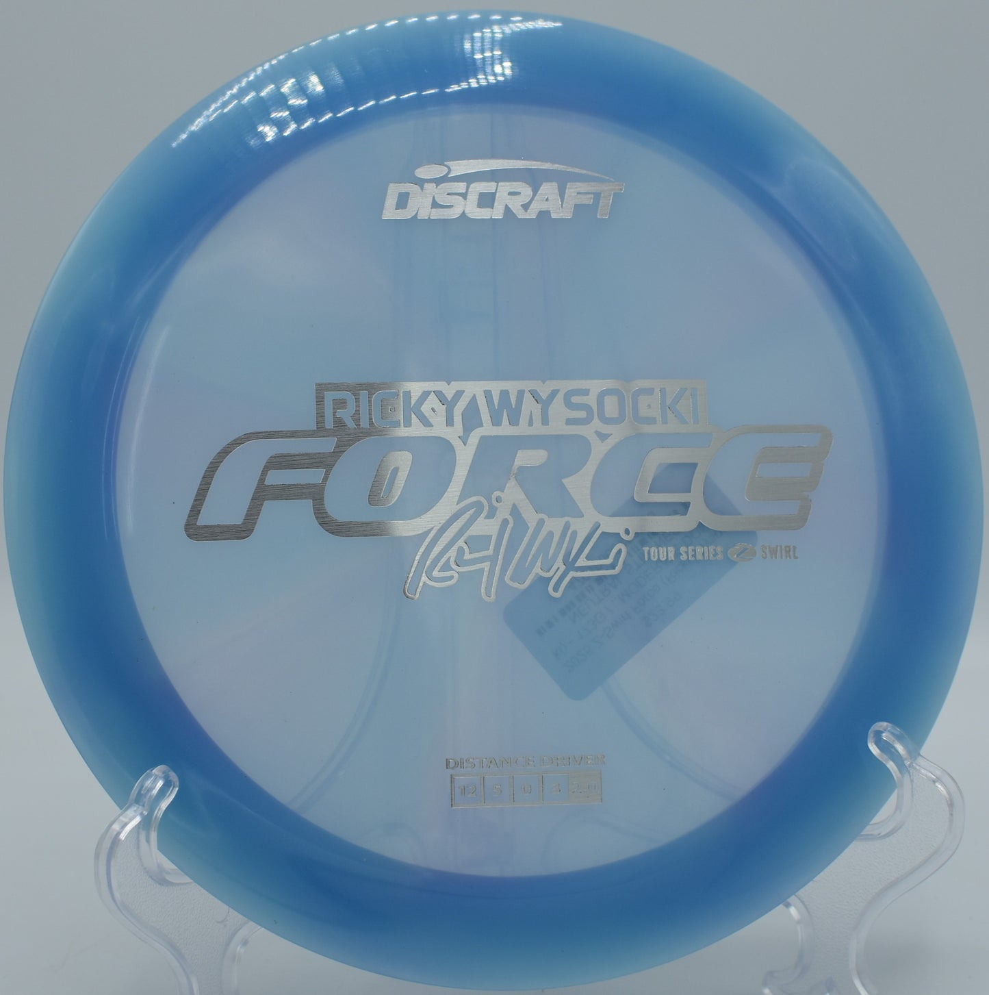 Discraft Force tracking a flex S-curve through a tree-lined gap at Camp Sekani.

