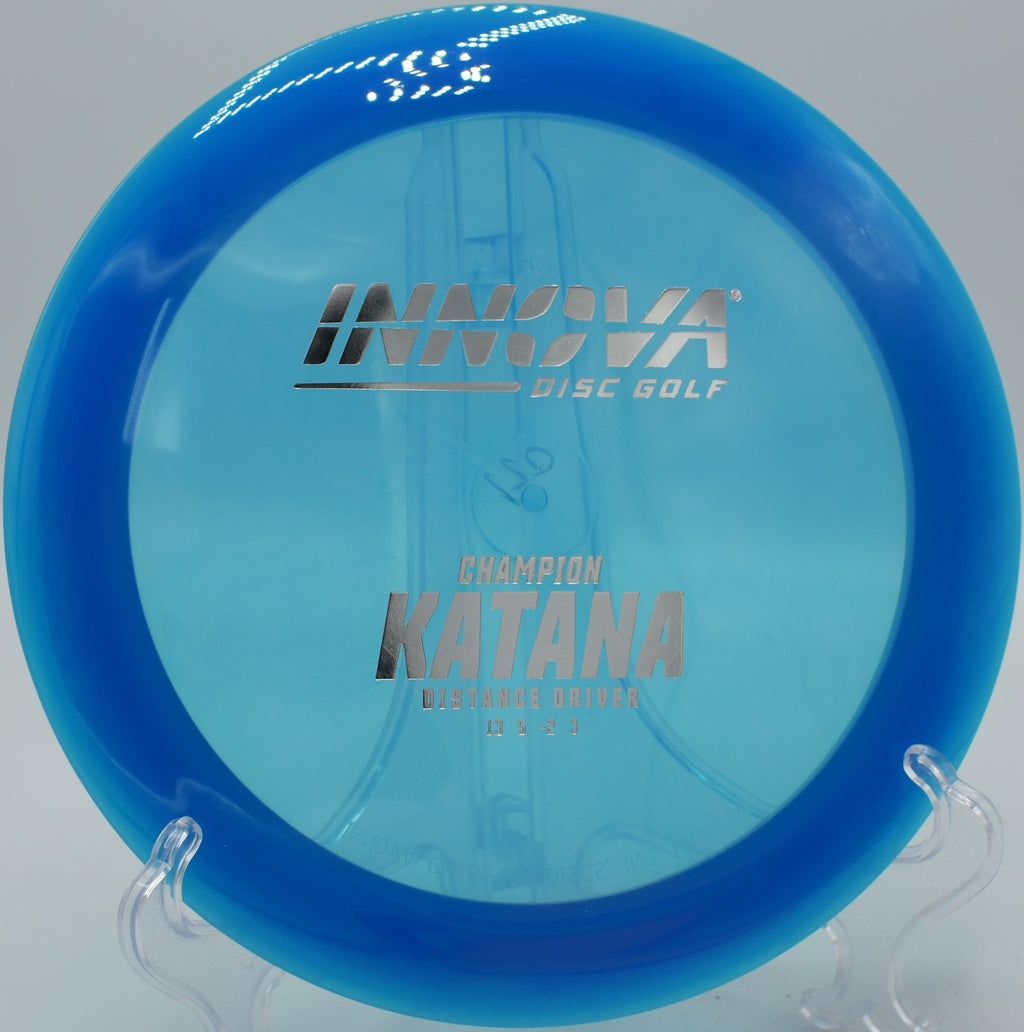An Innova Champion Katana carving a long flex shot through the fairway at Harmony Bends Disc Golf Course in Columbia, Missouri, showcasing its high-speed distance potential.