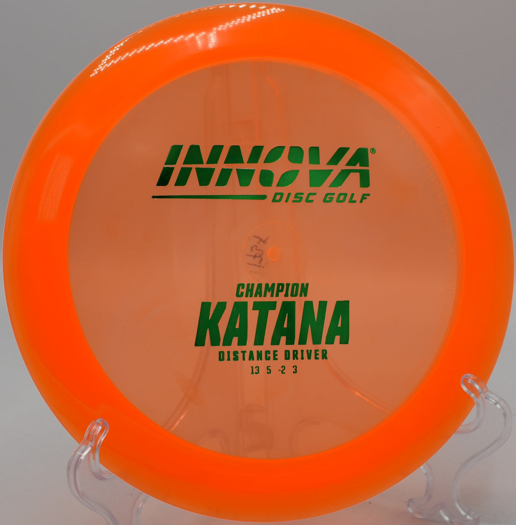A disc golfer launching a booming forehand drive with a Champion Katana at Stafford Woods Disc Golf Course in Voorhees Township, New Jersey, maximizing turn and glide.