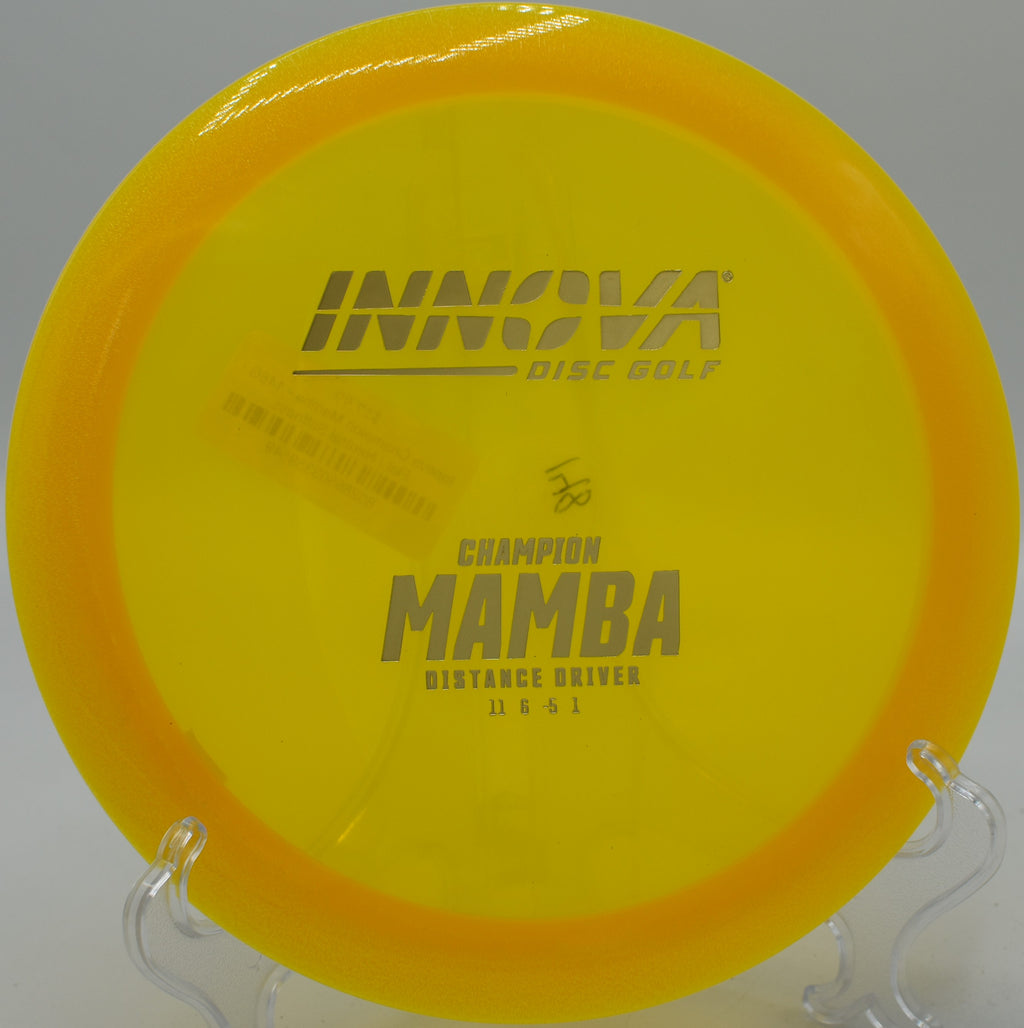 An Innova Champion Mamba parked next to the basket at Heritage Park Disc Golf Course in Olathe, Kansas, after a controlled fairway shot.