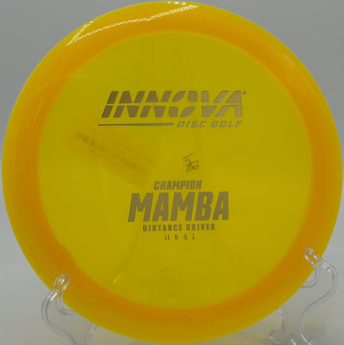 An Innova Champion Mamba parked next to the basket at Heritage Park Disc Golf Course in Olathe, Kansas, after a controlled fairway shot.