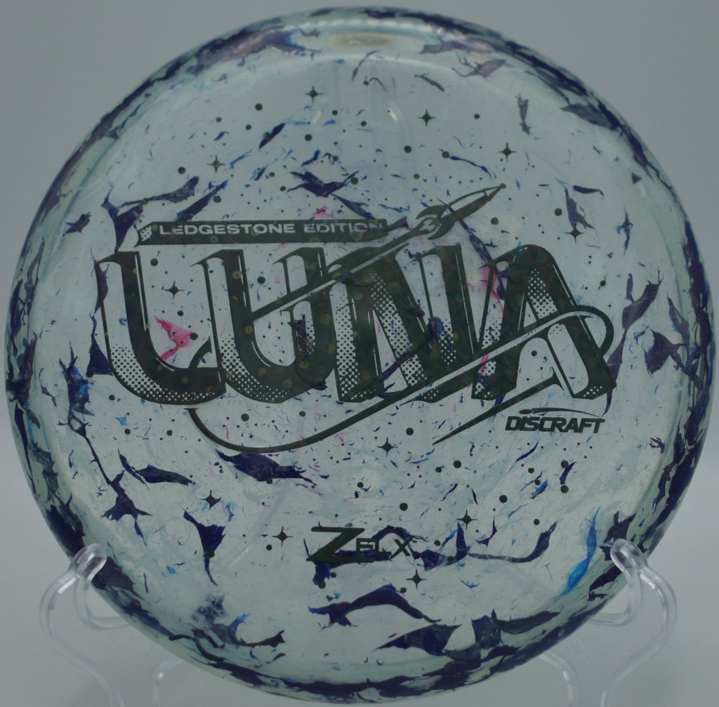 Discraft Jawbreaker Z Super Flx Luna showing flexible plastic texture on a putting green at Blue Ribbon Pines Disc Golf Course in East Bethel, Minnesota
