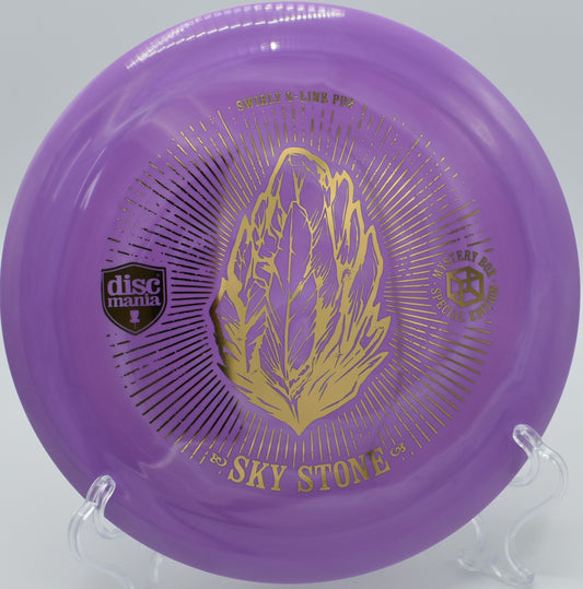 "Sky Stone PD2 distance driver in vibrant colors, photographed on a tee pad at Steilacoom Disc Golf Course."