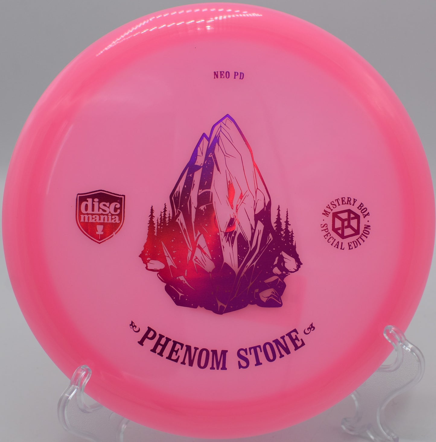 "Neo Essence The Phenom Stone disc, designed for precision shots, lying on the fairway at Harmony Bends Disc Golf Course in Columbia, MO."
