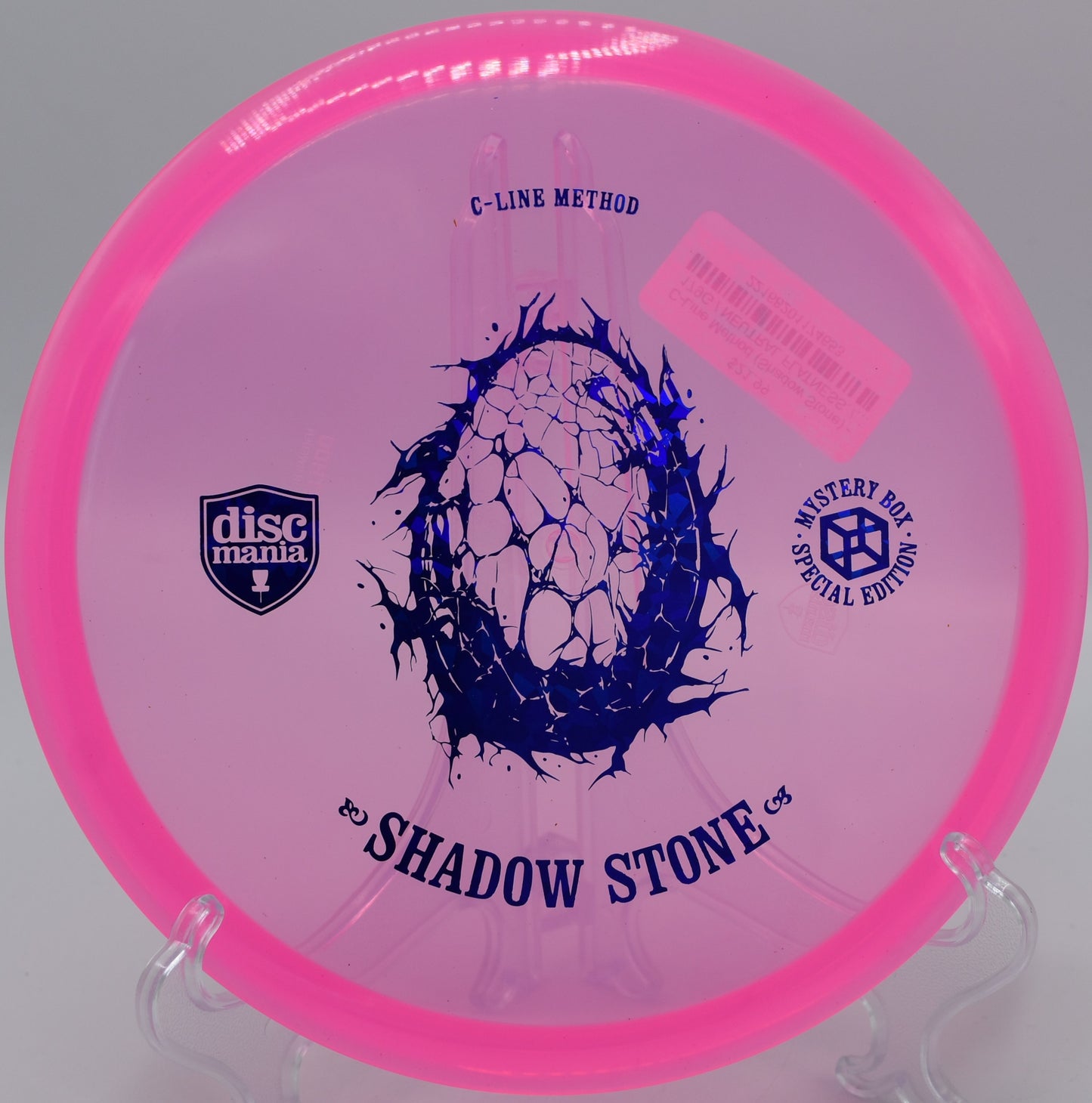 "Shadow Stone midrange disc resting near a basket at DeLaveaga Disc Golf Course in Santa Cruz, California, highlighting its accuracy."
