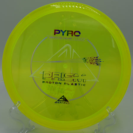 Prism Proton Pyro disc resting on a tee pad at Golden Gate Park Disc Golf Course in San Francisco, California, showcasing its vibrant design and high-quality Prism Proton plastic.