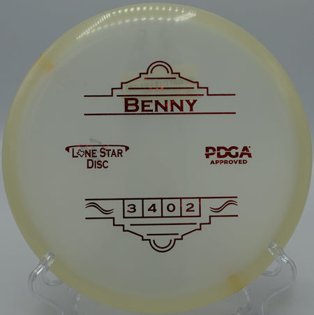 "Close-up of the Lone Star Glow Benny putter on a tee pad at Rivery Disc Golf Course in Georgetown, Texas, showcasing its premium glow plastic."
