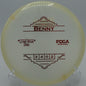"Close-up of the Lone Star Glow Benny putter on a tee pad at Rivery Disc Golf Course in Georgetown, Texas, showcasing its premium glow plastic."
