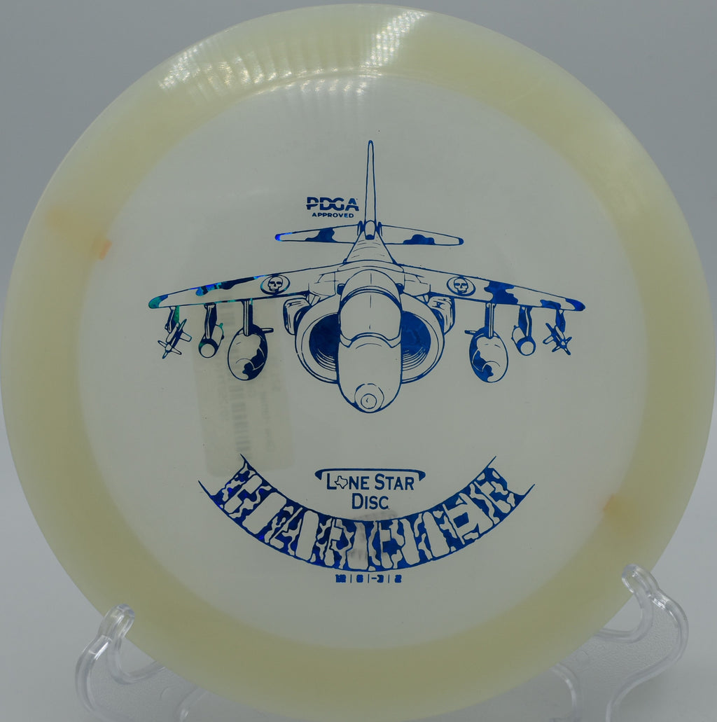 "Lone Star Glow Harrier disc flying smoothly over open terrain at Mossy Roc Disc Golf Course in Port Angeles, Washington, showcasing its precision."

