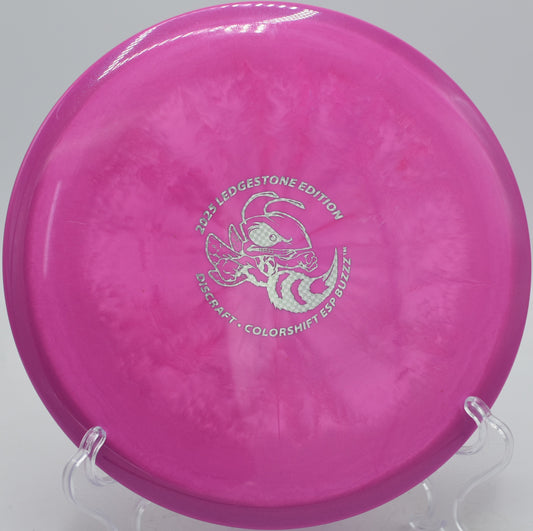 Discraft Colorshift ESP Buzzz midrange flying straight at Maple Hill Disc Golf Course in Leicester, Massachusetts