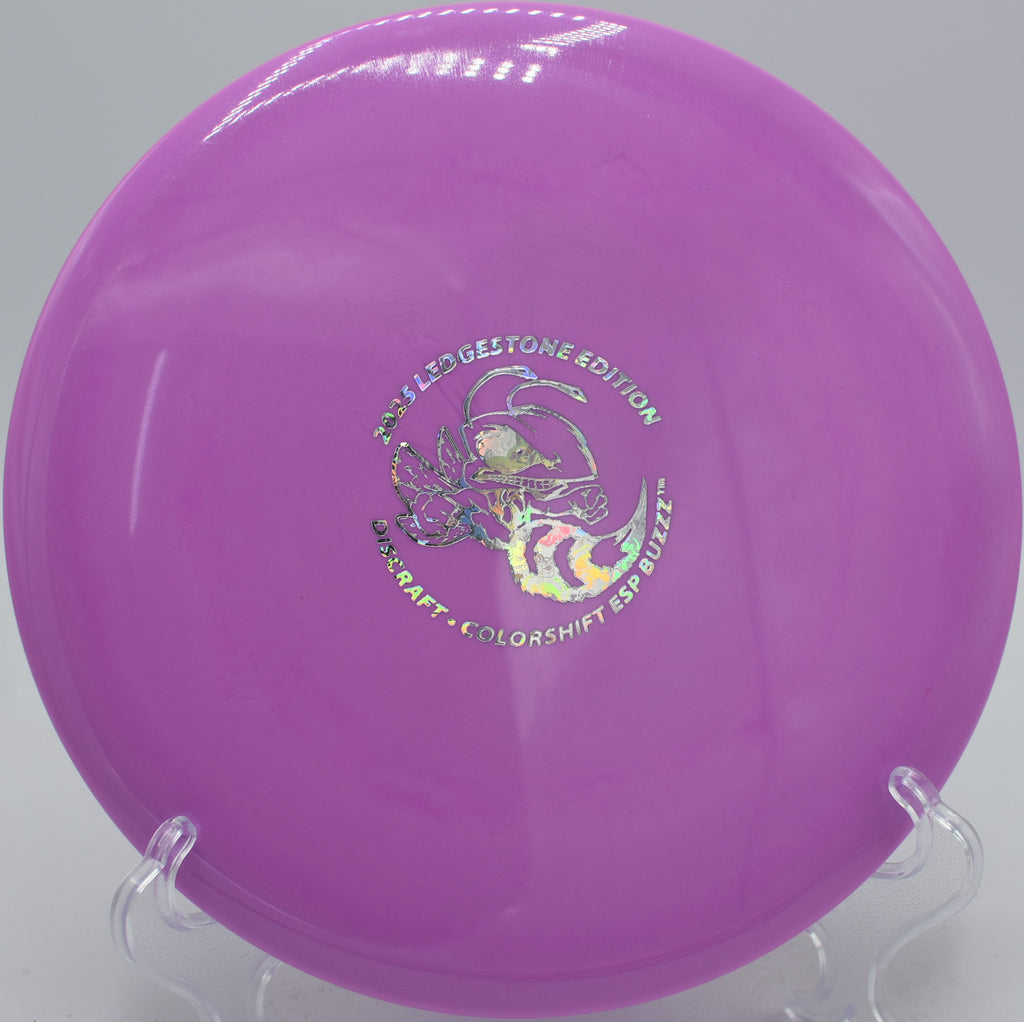 Colorshift ESP Buzzz thrown flat on a wooded fairway at Idlewild Disc Golf Course in Burlington, Kentucky