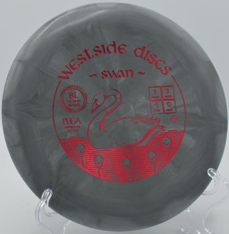 BT Burst Medium Swan resting under the basket on a wooded green at Idlewild Disc Golf Course in Burlington, Kentucky.

