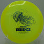 Close-up of the glowing Bio Lumen Essence resting on a tee pad at Condon Park Disc Golf Course in Grass Valley, California

