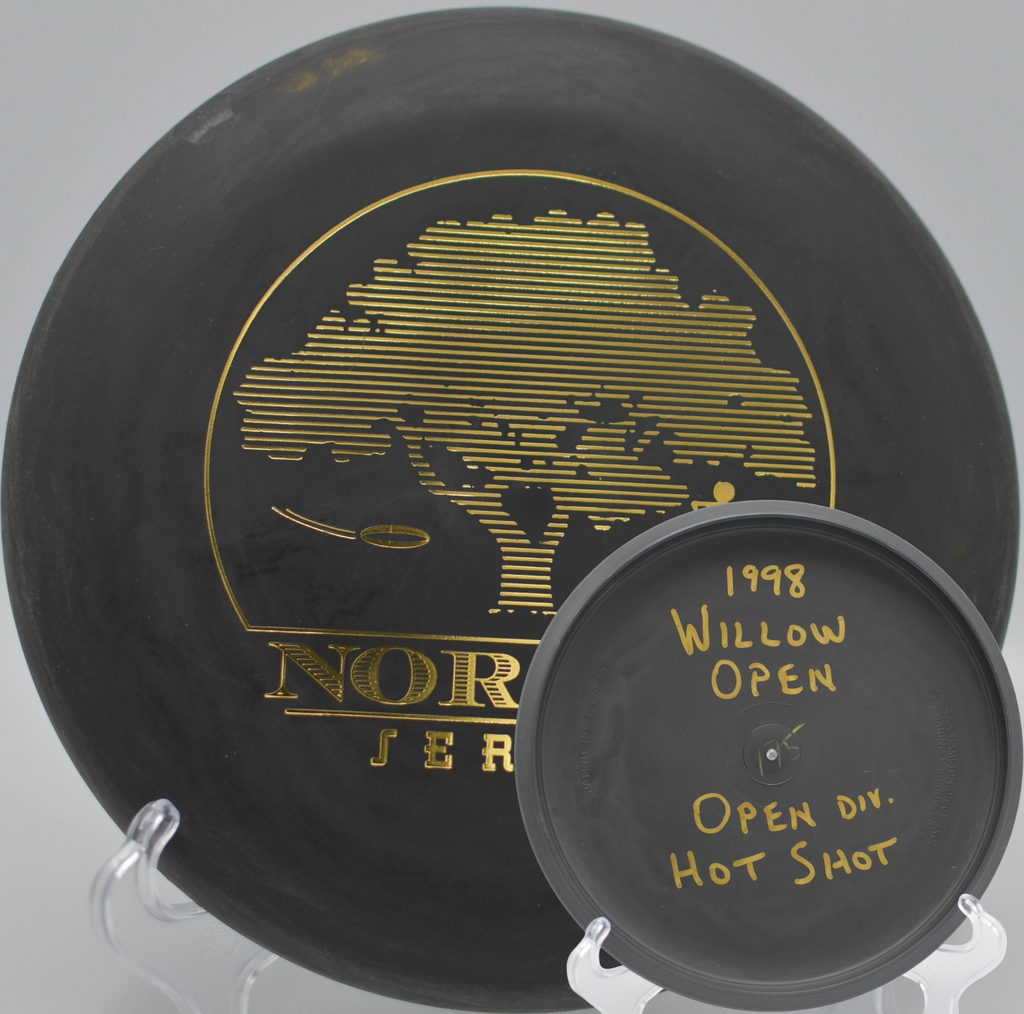 Black 2-Ring San Marino Microbead Aviar w/Pat# (NorCal Series 97–02) flying low under oak trees at Rocklin Disc Golf Course in Rocklin, California.