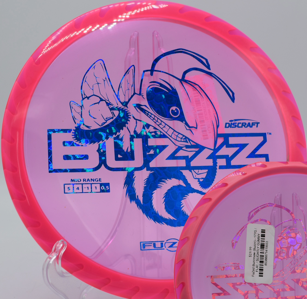 Discraft’s Fuzed Buzzzsaw midrange resting near the basket at Blue Ribbon Pines in East Bethel, Minnesota, known for its strong finish and consistent feel.

