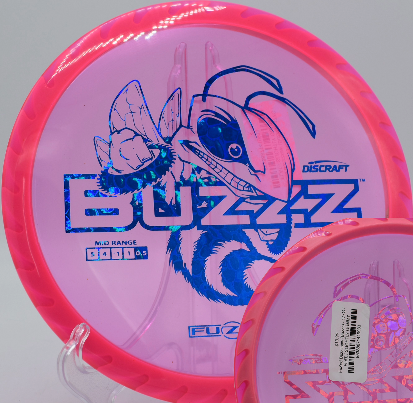 Discraft’s Fuzed Buzzzsaw midrange resting near the basket at Blue Ribbon Pines in East Bethel, Minnesota, known for its strong finish and consistent feel.

