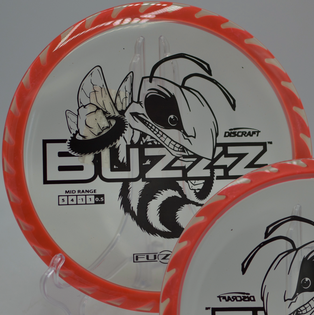 Discraft Fuzed Buzzzsaw resting near the chains after a clean release at Sabattus Disc Golf Complex in Sabattus, Maine.