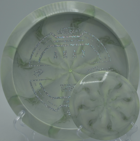 2025 Anax collaboration disc positioned on a concrete tee at SeaTac DGC in SeaTac, WA, emphasizing its glide-heavy 6-rated flight.