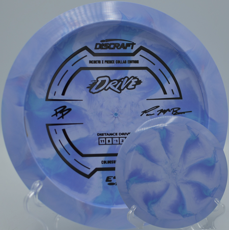 2025 Paige Pierce & Paul McBeth ESP Drive Collab resting on the tee pad at Blue Ribbon Pines DGC in East Bethel, MN, showcasing its 11-speed distance flight.