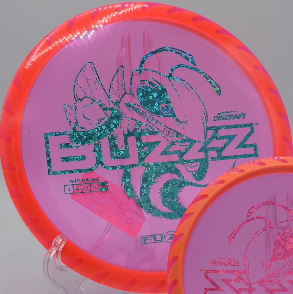 Fuzed Buzzzsaw with sawblade rim aesthetic resting in tall grass at Trophy Lakes DGC in Johns Island, South Carolina, offering stable accuracy.

