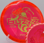 Buzzzsaw midrange by Discraft lying on sun-warmed earth at El Do Disc Golf Course in Long Beach, California, perfect for line shaping and wind-fighting.

