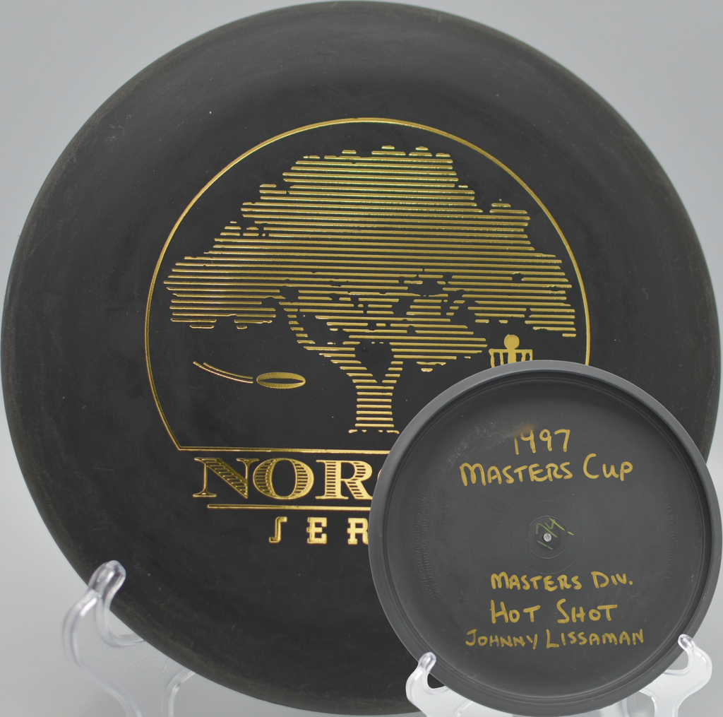 Black 2-Ring San Marino Microbead Aviar w/Pat# (NorCal Series 97–02) resting under redwoods at DeLaveaga Disc Golf Course in Santa Cruz, California.