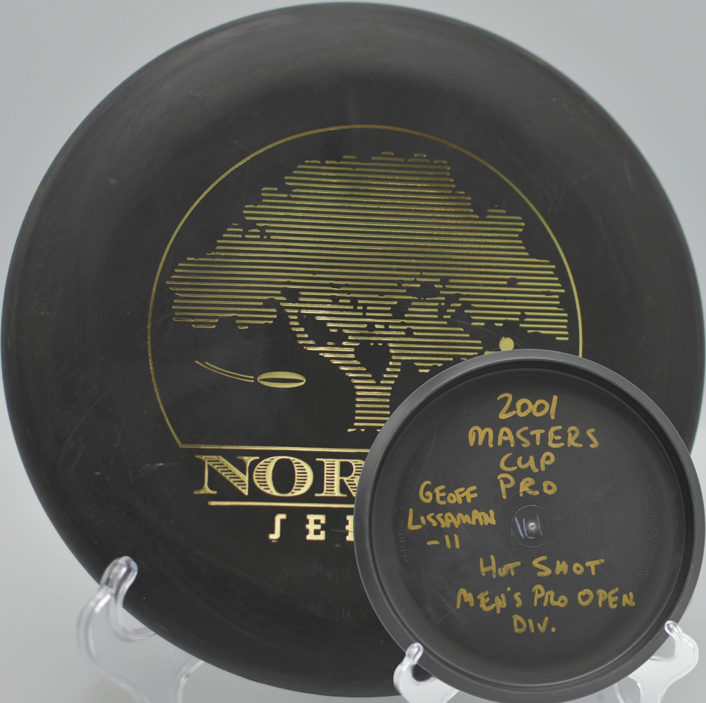 Black 2-Ring San Marino Microbead Aviar w/Pat# (NorCal Series 97–02) laying up beside the basket at Whiskeytown Lake Disc Golf Course in Redding, California.