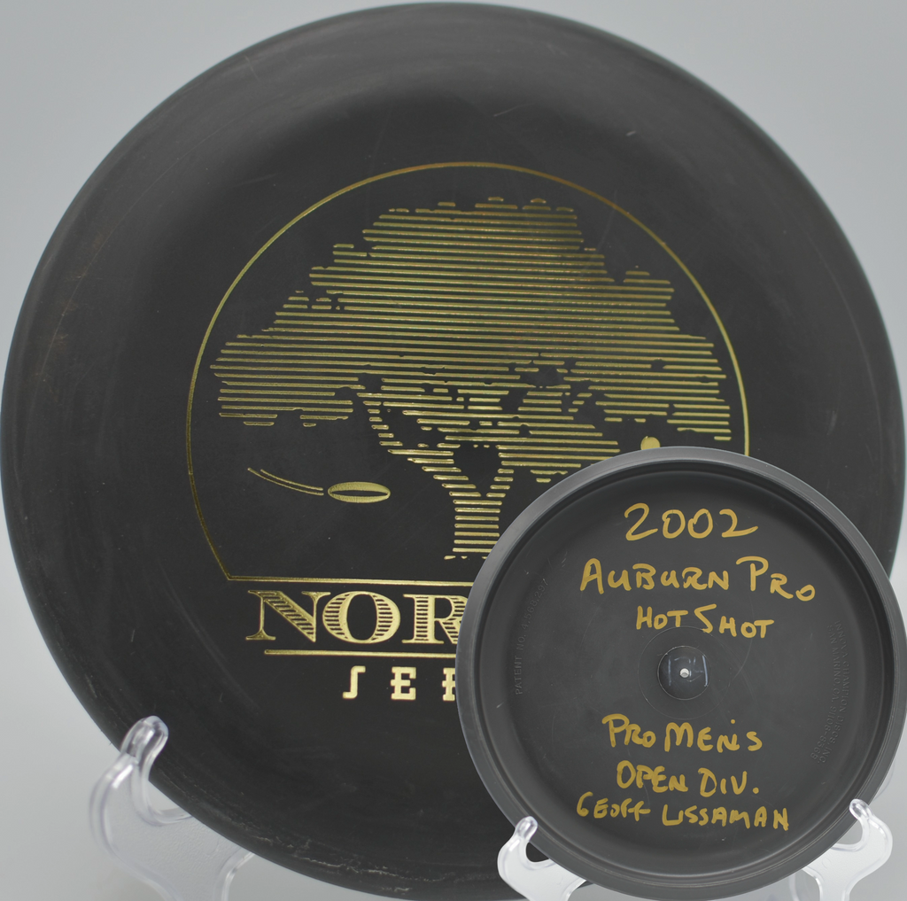 Black 2-Ring San Marino Microbead Aviar w/Pat# (NorCal Series 97–02) held in hand on the tee pad at Feather River Park Disc Golf Course in Oroville, California.