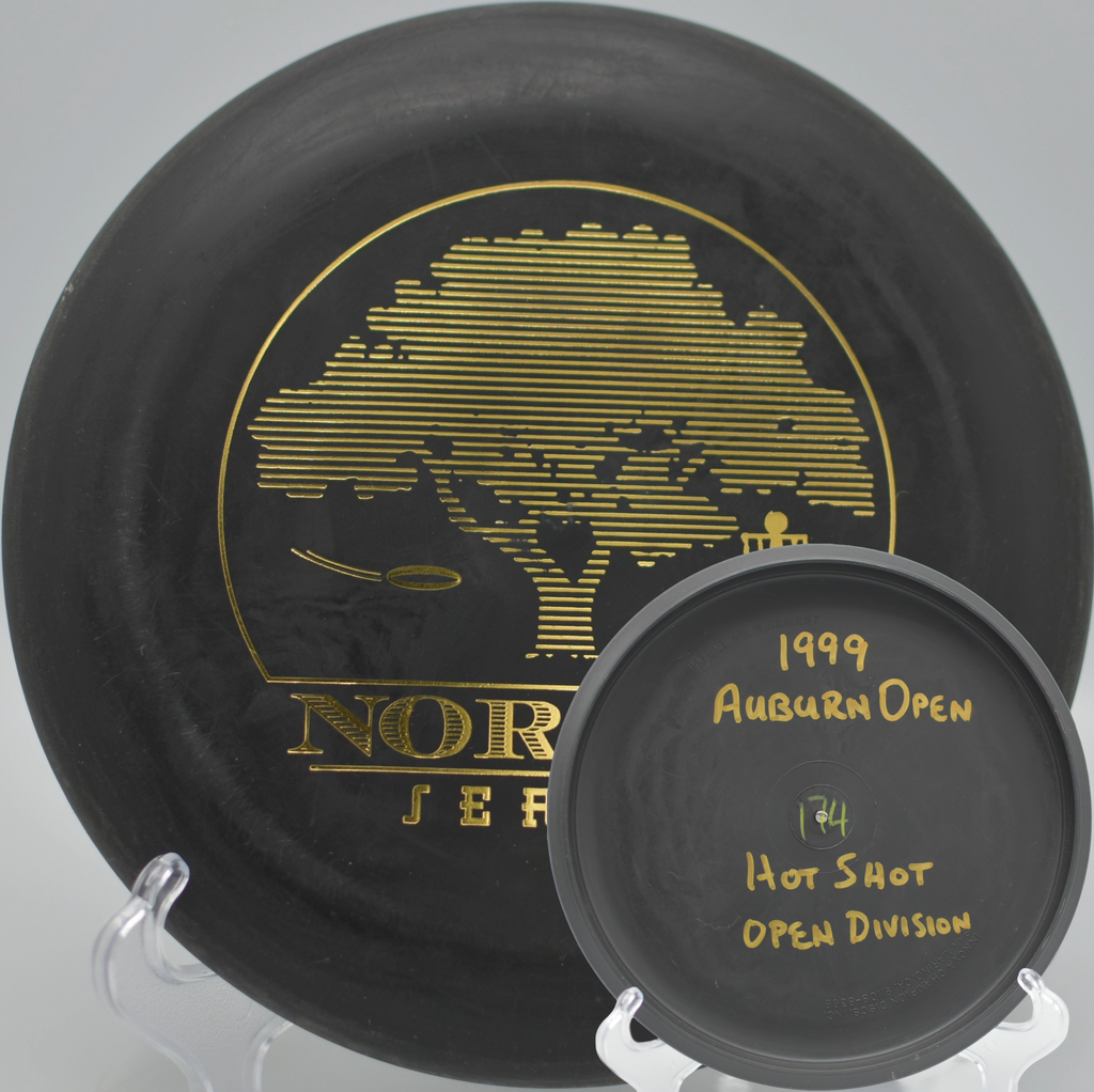 Black 2-Ring San Marino Microbead Aviar w/Pat# (NorCal Series 97–02) caught mid-flight through pines at Bidwell Park Disc Golf Course in Chico, California.