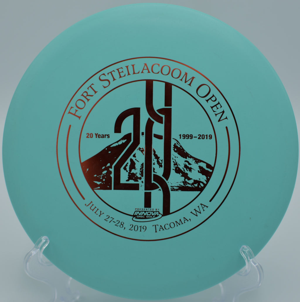 Disc golfer using DX Roc for precise hyzer shots at Tacoma, WA disc golf park, showcasing its stability even in headwinds. Available nationwide.